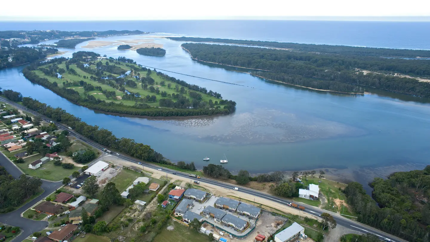 Aerial view of a waterside settlement, houses and roads following the shoreline.